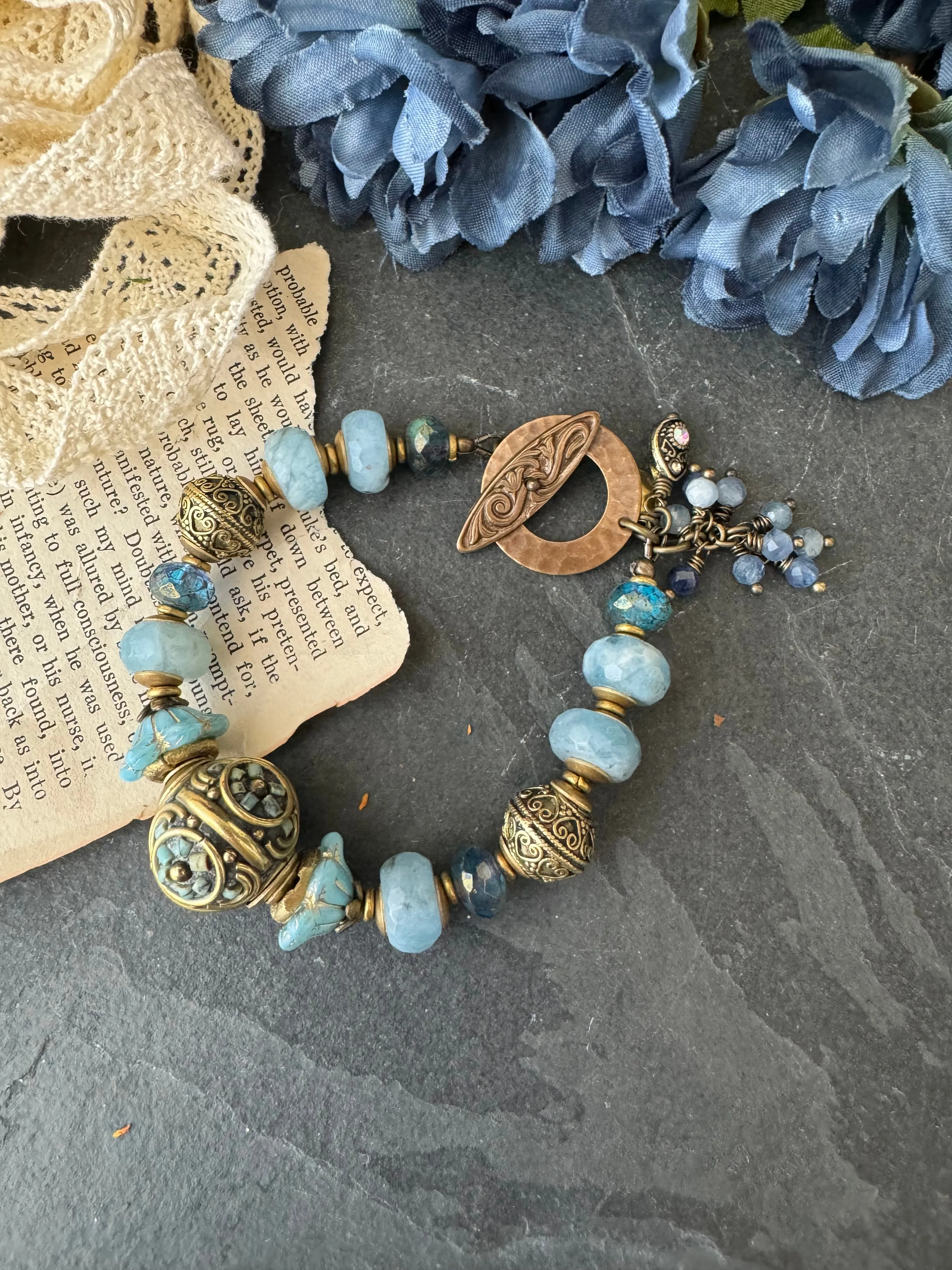 Aquamarine stone, African brass, Czech glass, Indonesian bead with flower detail.