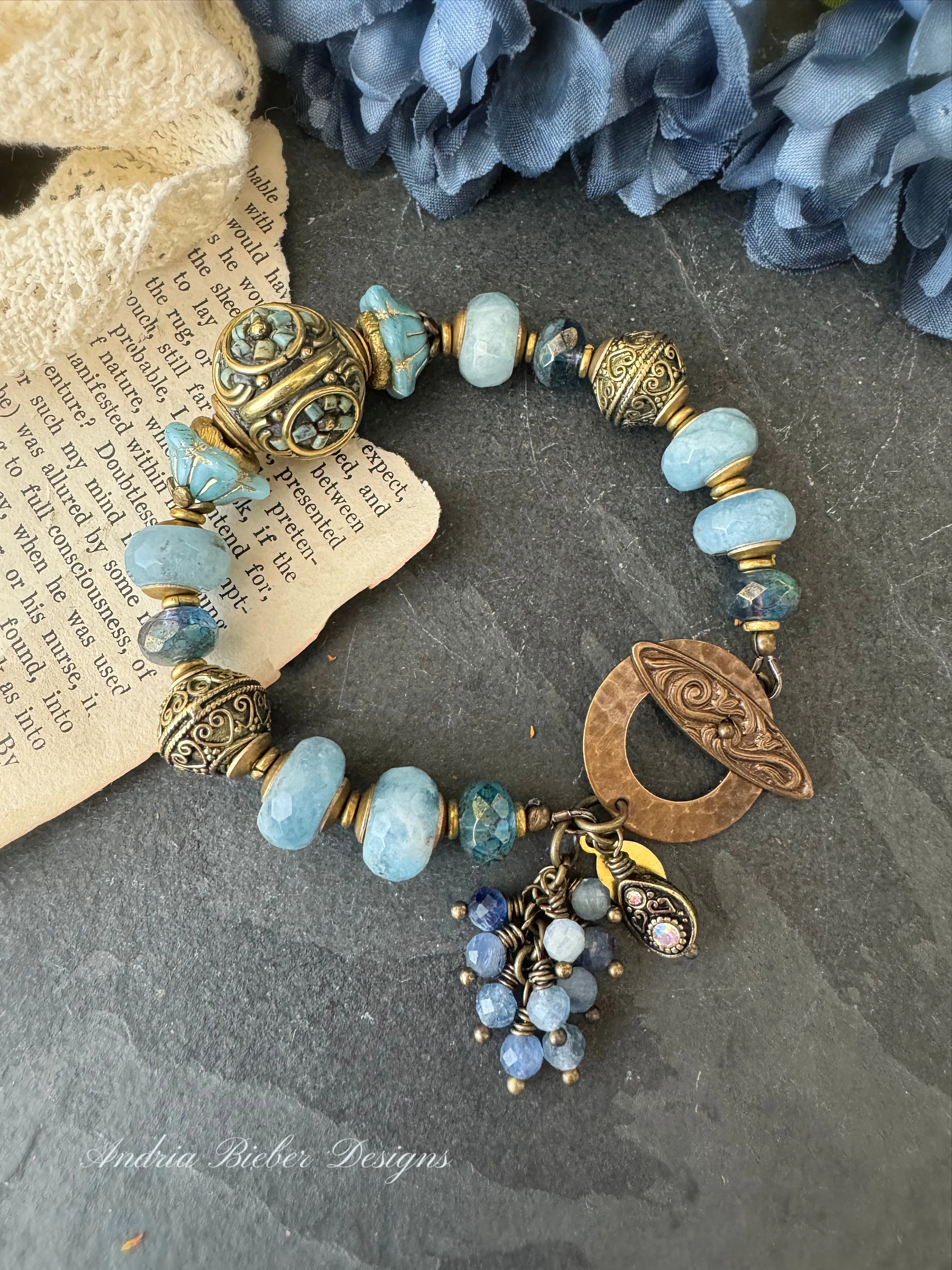 Aquamarine stone, African brass, Czech glass, Indonesian bead with flower detail.